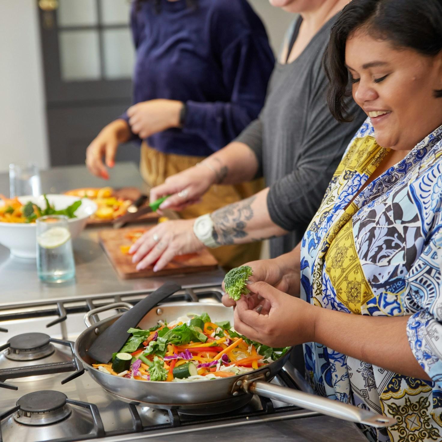 Diverse group of community members sharing a meal together, showcasing the social bonds formed through collaborative cooking